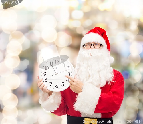 Image of man in costume of santa claus with clock