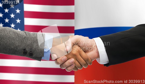 Image of handshake over american and russian flags