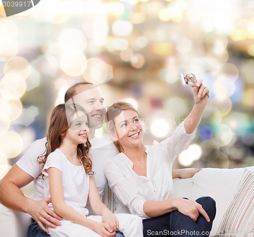 Image of happy family with camera at home