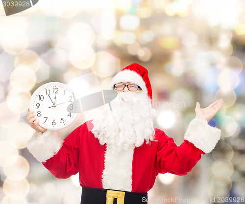 Image of man in costume of santa claus with clock