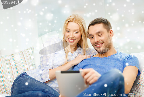 Image of smiling happy couple with tablet pc at home