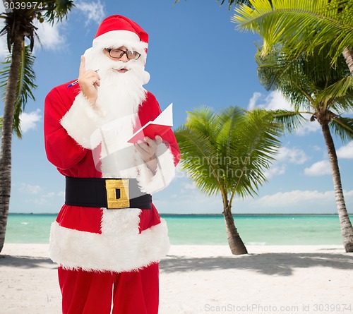 Image of man in costume of santa claus with notepad