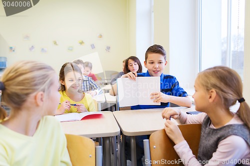 Image of group of school kids writing test in classroom