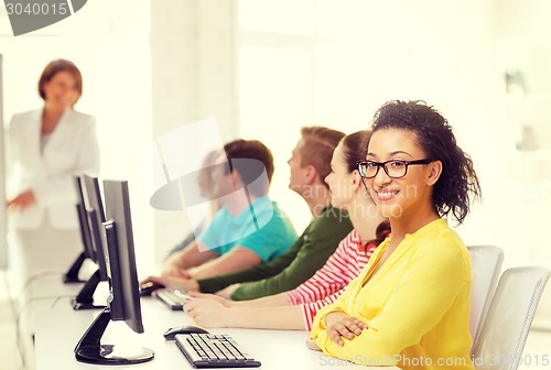 Image of female student with classmates in computer class