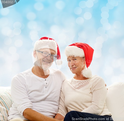 Image of happy senior couple in santa helper hats