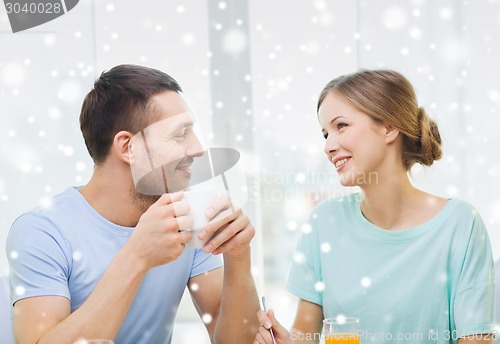 Image of smiling couple having breakfast at home