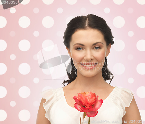 Image of smiling young woman with flower