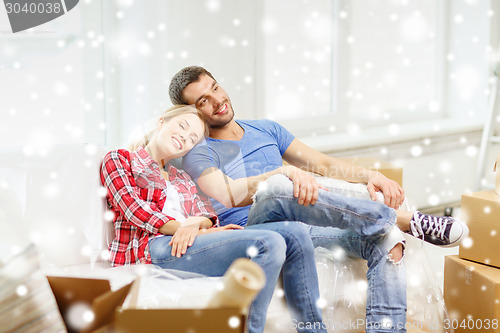 Image of smiling couple relaxing on sofa in new home