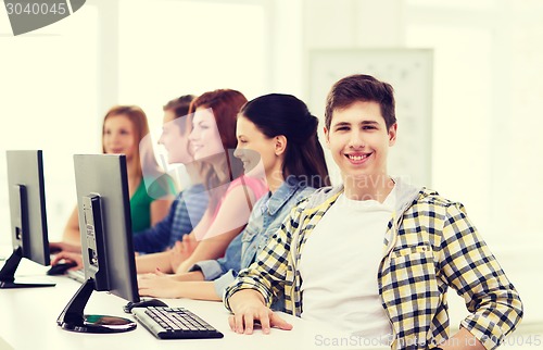 Image of male student with classmates in computer class