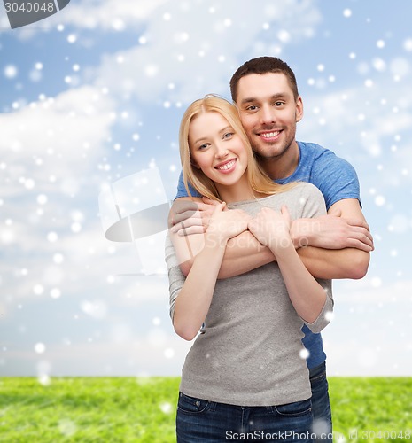 Image of happy couple hugging outdoors