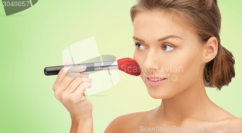 Image of beautiful smiling woman with make up brush