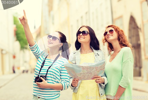 Image of smiling teenage girls with map and camera