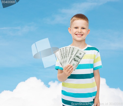 Image of smiling boy holding dollar cash money in his hand