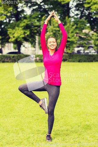 Image of smiling woman exercising outdoors