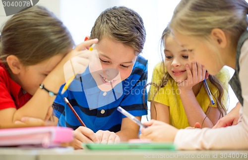 Image of group of students talking and writing at school