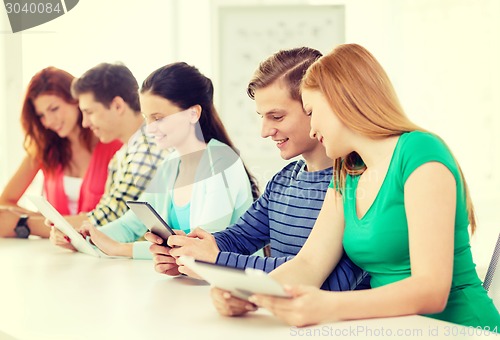 Image of smiling students with tablet pc at school