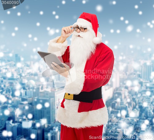 Image of man in costume of santa claus with tablet pc