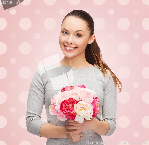 Image of smiling young woman with flower