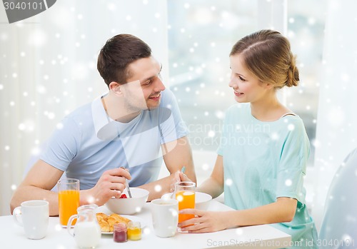 Image of smiling couple having breakfast at home