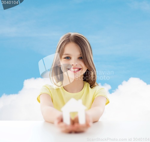 Image of beautiful little girl holding paper house cutout