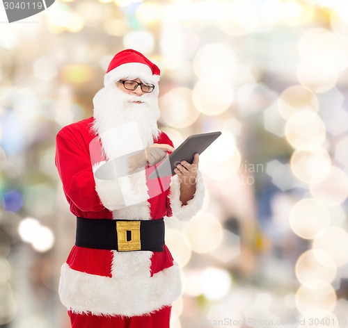 Image of man in costume of santa claus with tablet pc