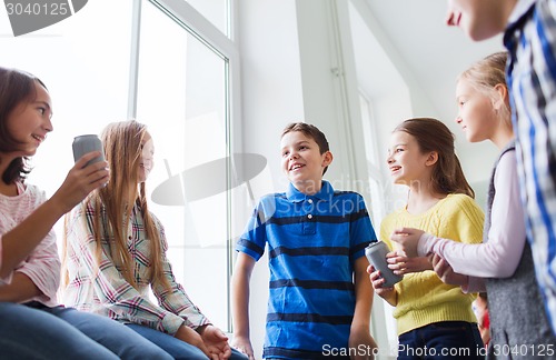 Image of group of school kids with soda cans in corridor