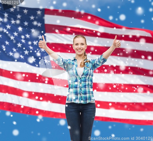 Image of smiling girl in casual clothes showing thumbs up