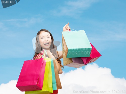 Image of smiling woman with colorful shopping bags