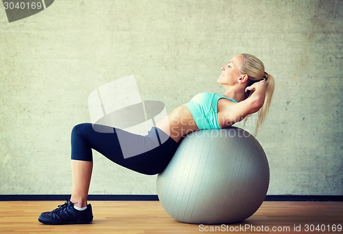 Image of smiling woman with exercise ball in gym