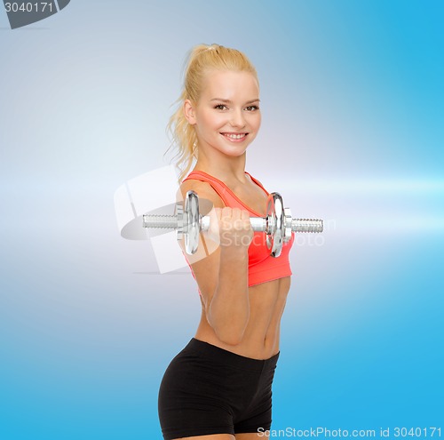 Image of young sporty woman with heavy steel dumbbell