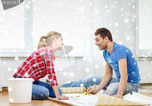 Image of smiling couple measuring wallpaper