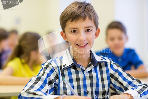 Image of group of school kids writing test in classroom