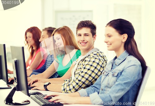 Image of smiling student with computer studying at school