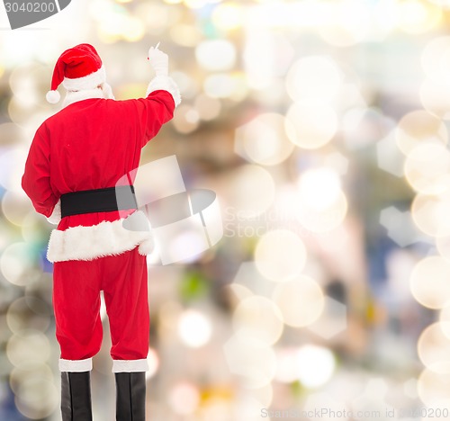 Image of man in costume of santa claus writing something