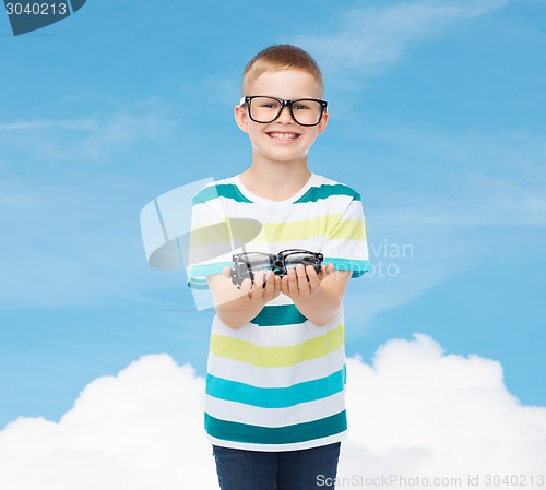 Image of smiling boy in eyeglasses holding spectacles