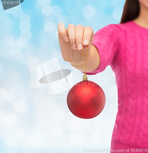 Image of close up of woman in sweater with christmas ball