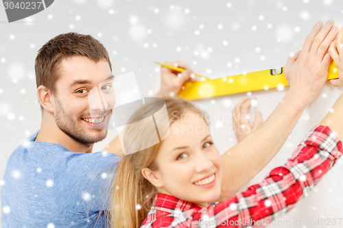 Image of couple building using spirit level to measure