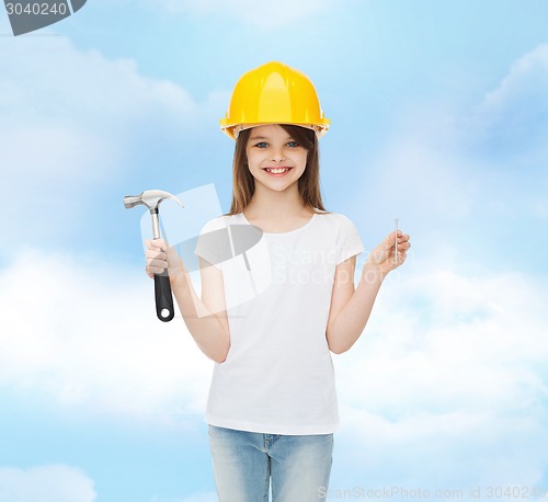 Image of smiling little girl in hardhat with hammer