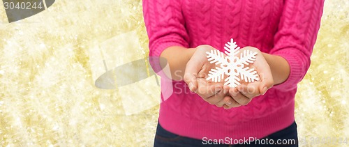 Image of close up of woman holding snowflake decoration