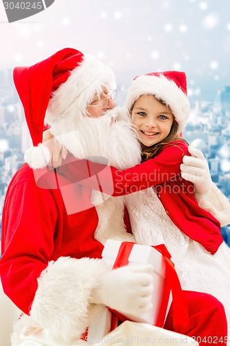 Image of smiling little girl with santa claus and gifts