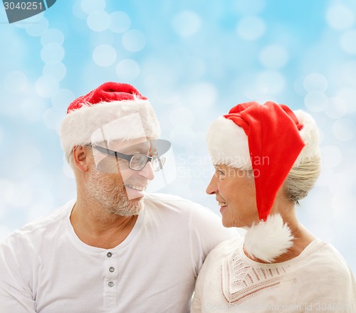 Image of happy senior couple in santa helper hats