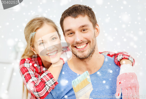 Image of smiling couple with paintbrush at home