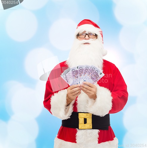 Image of man in costume of santa claus with euro money