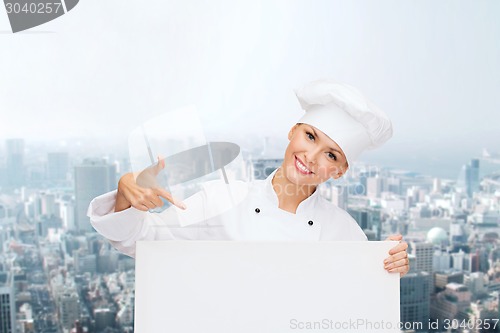 Image of smiling female chef with white blank board