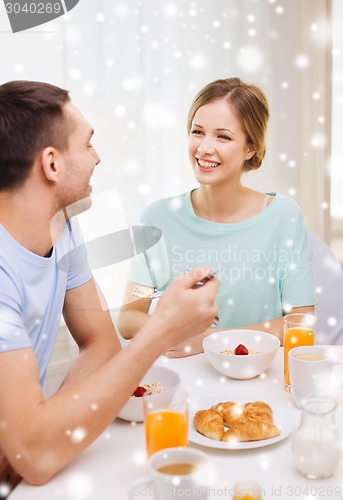 Image of smiling couple having breakfast at home