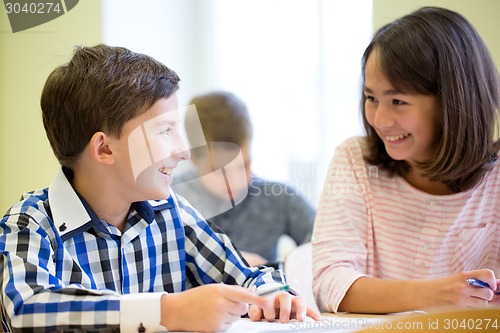 Image of group of school kids writing test in classroom