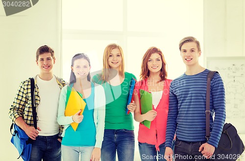 Image of smiling students with bags and folders at school