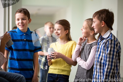 Image of group of school kids with soda cans in corridor