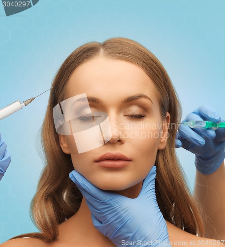 Image of beautiful woman face and hands with syringe