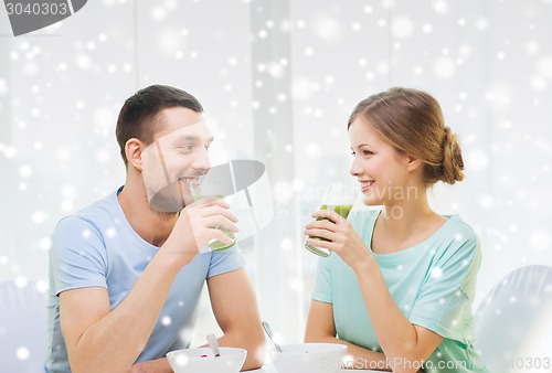 Image of smiling couple having breakfast at home